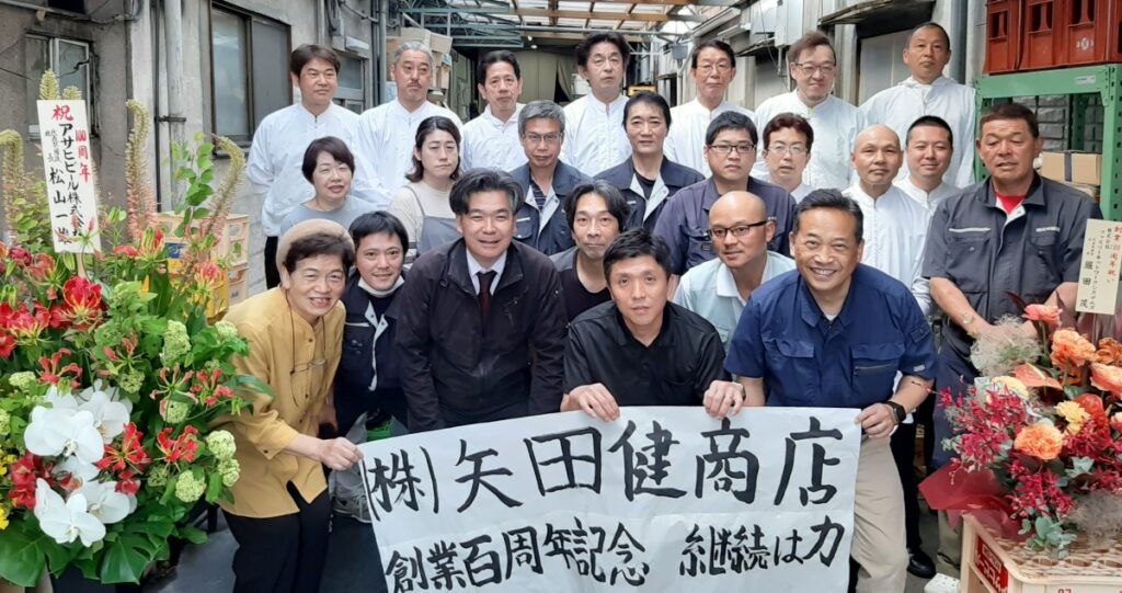矢田健商店100周年の記念撮影をしている画像